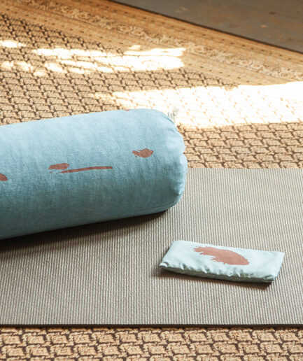 eye-pillow Shodô bleu et rouge et bolster de la même collection sur tapis de yoga