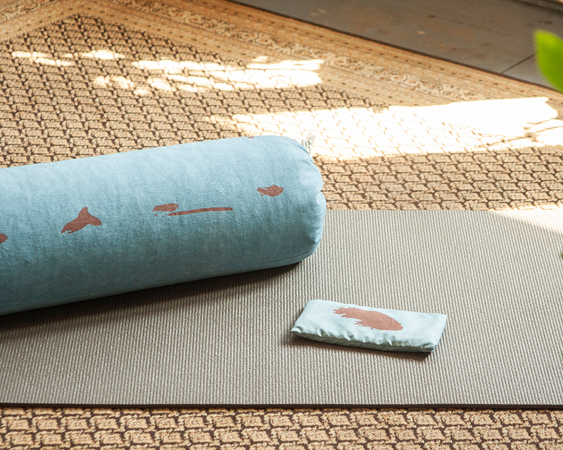 eye-pillow Shodô bleu et rouge et bolster de la même collection sur tapis de yoga
