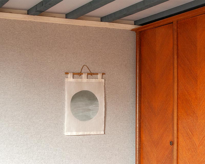 tenture murale sphère blanc à côté d'une armoire en bois
