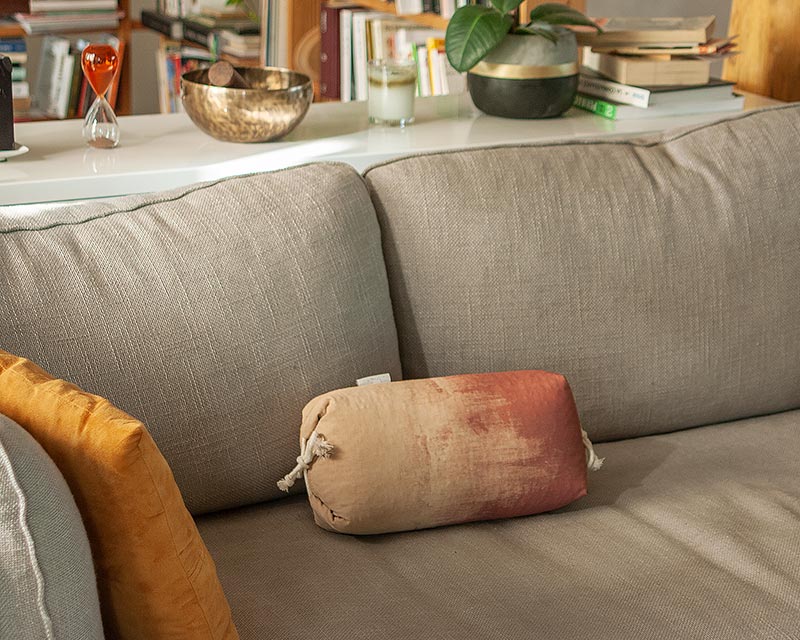 l'oreiller japonais Aura rouge dans un canapé gris de style minimaliste