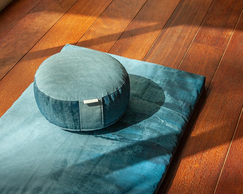 zafu bleu sur tapis de méditation bleu